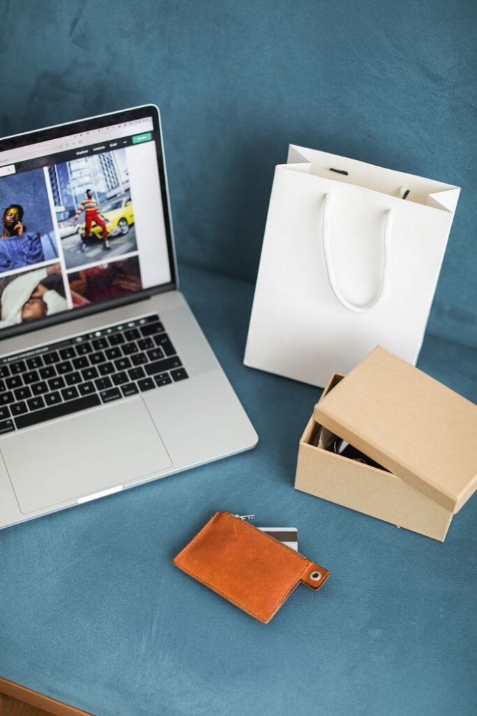 The Art of Drawing Readers In: Your attractive post title goes here A high-angle view of online shopping items including a laptop, gift bags, and wallet on a blue surface.